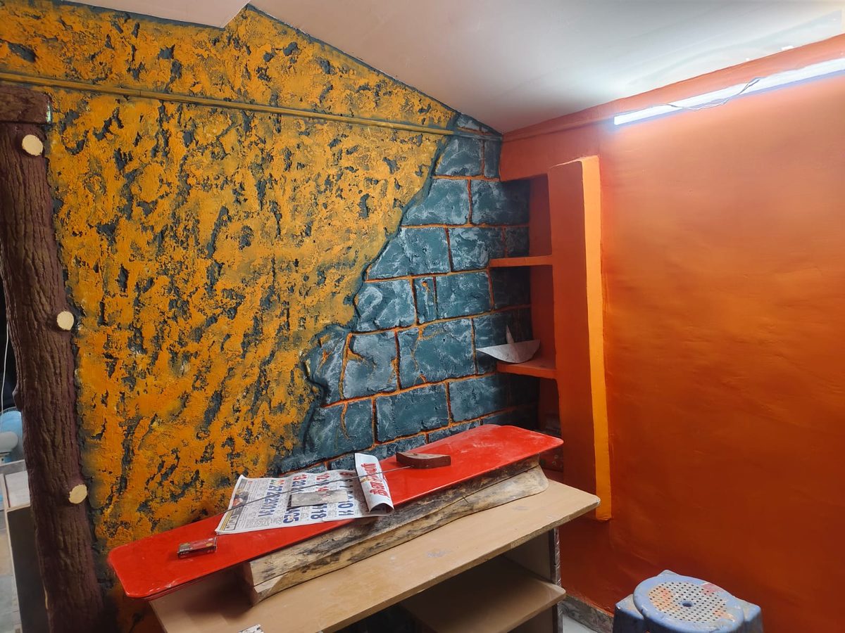 Blue-grey stone-pattern textured wall finish beside an orange wall