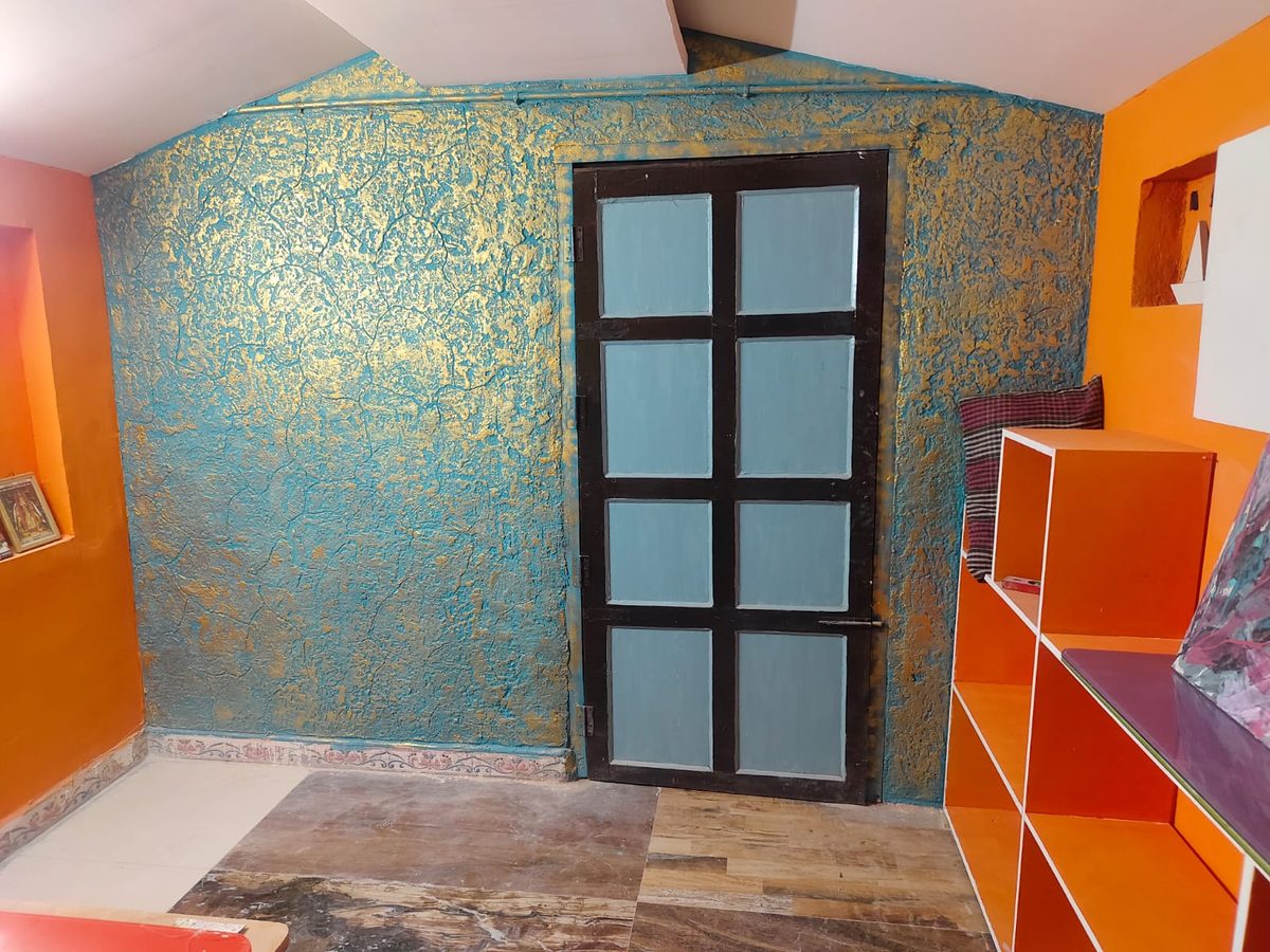 Metallic teal and gold textured plaster wall finish around a doorway
