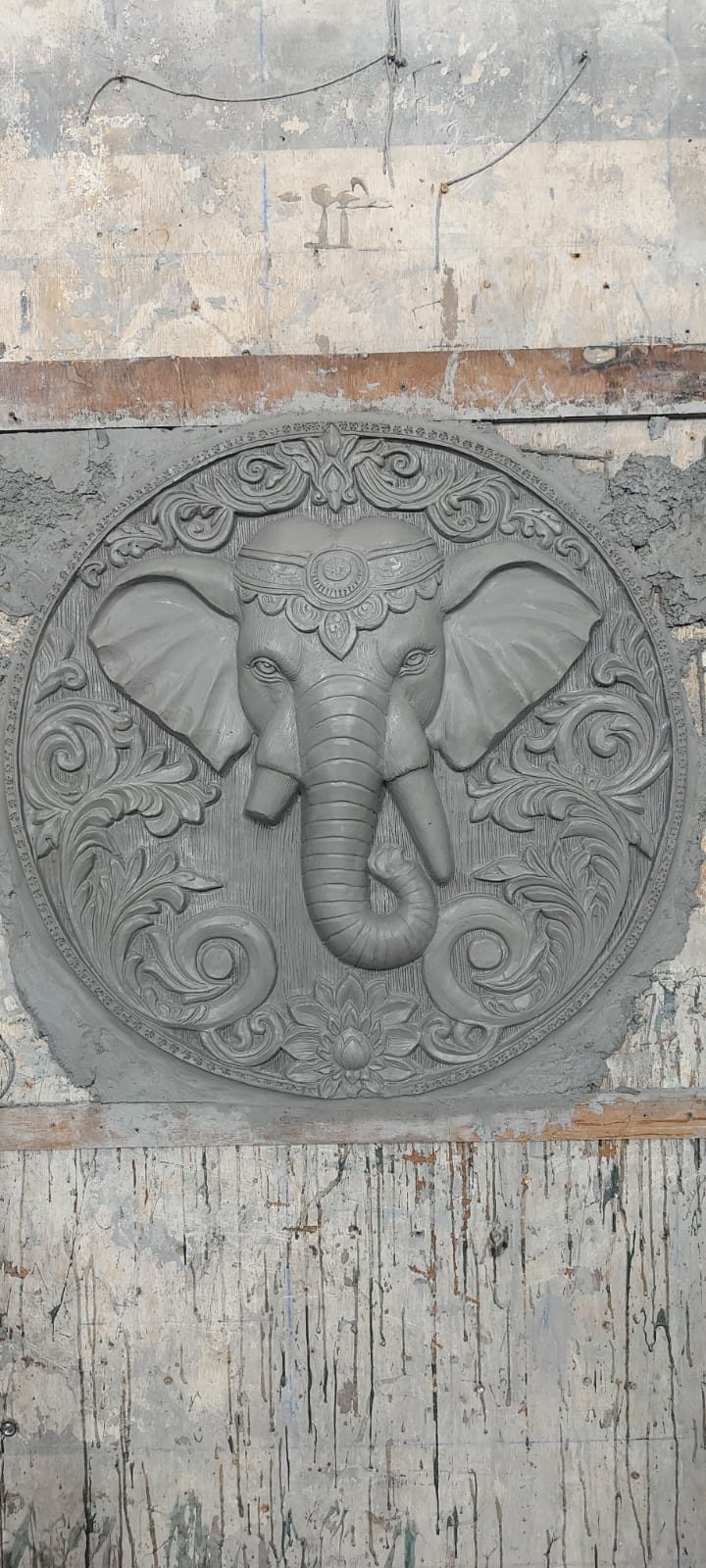 Circular relief medallion of an elephant head with floral border