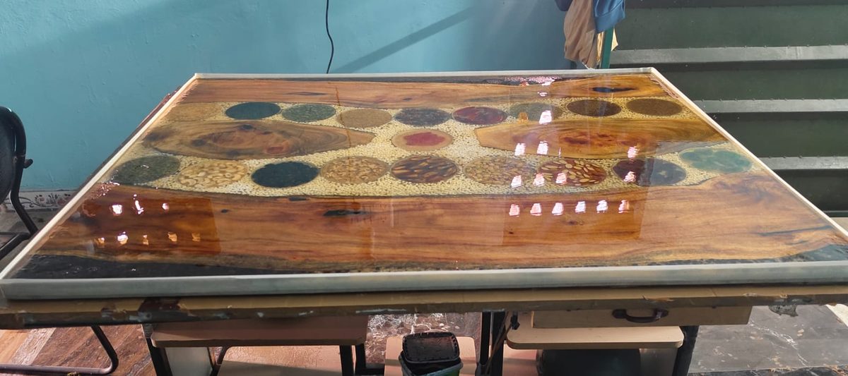 Wooden dining table with an epoxy resin river inlaid with colourful grains and pulses