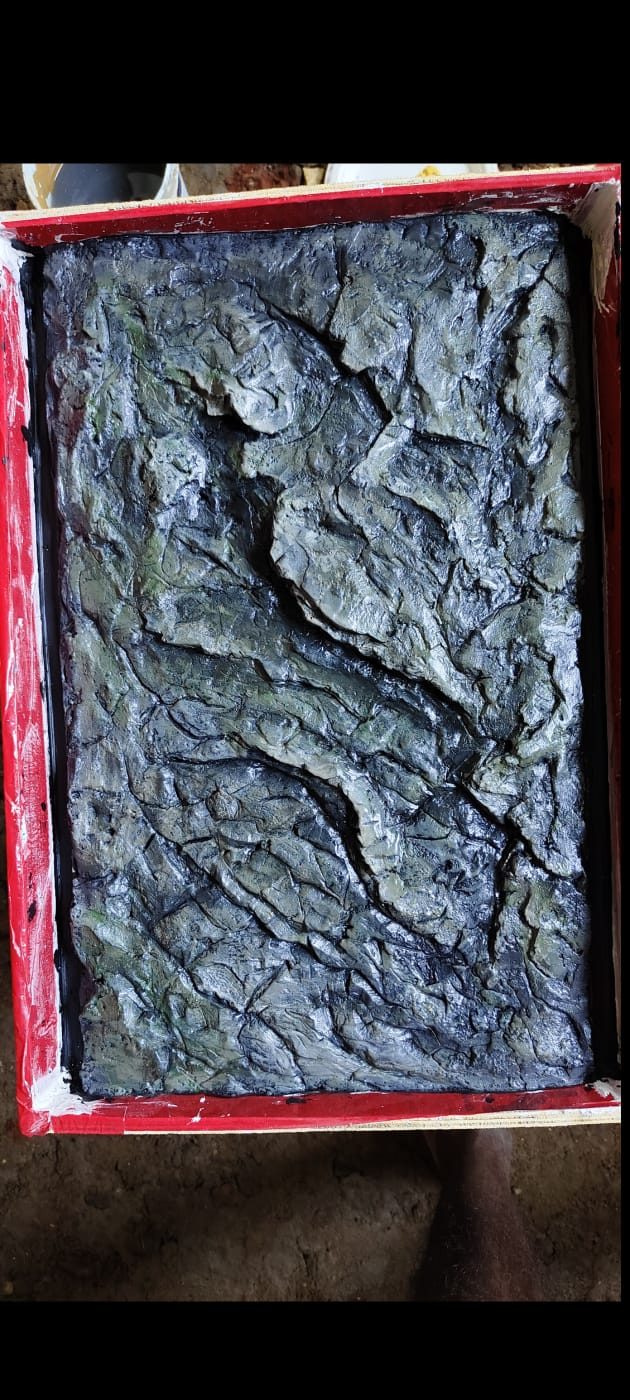 Dark textured rock-relief epoxy resin panel in a casting mould