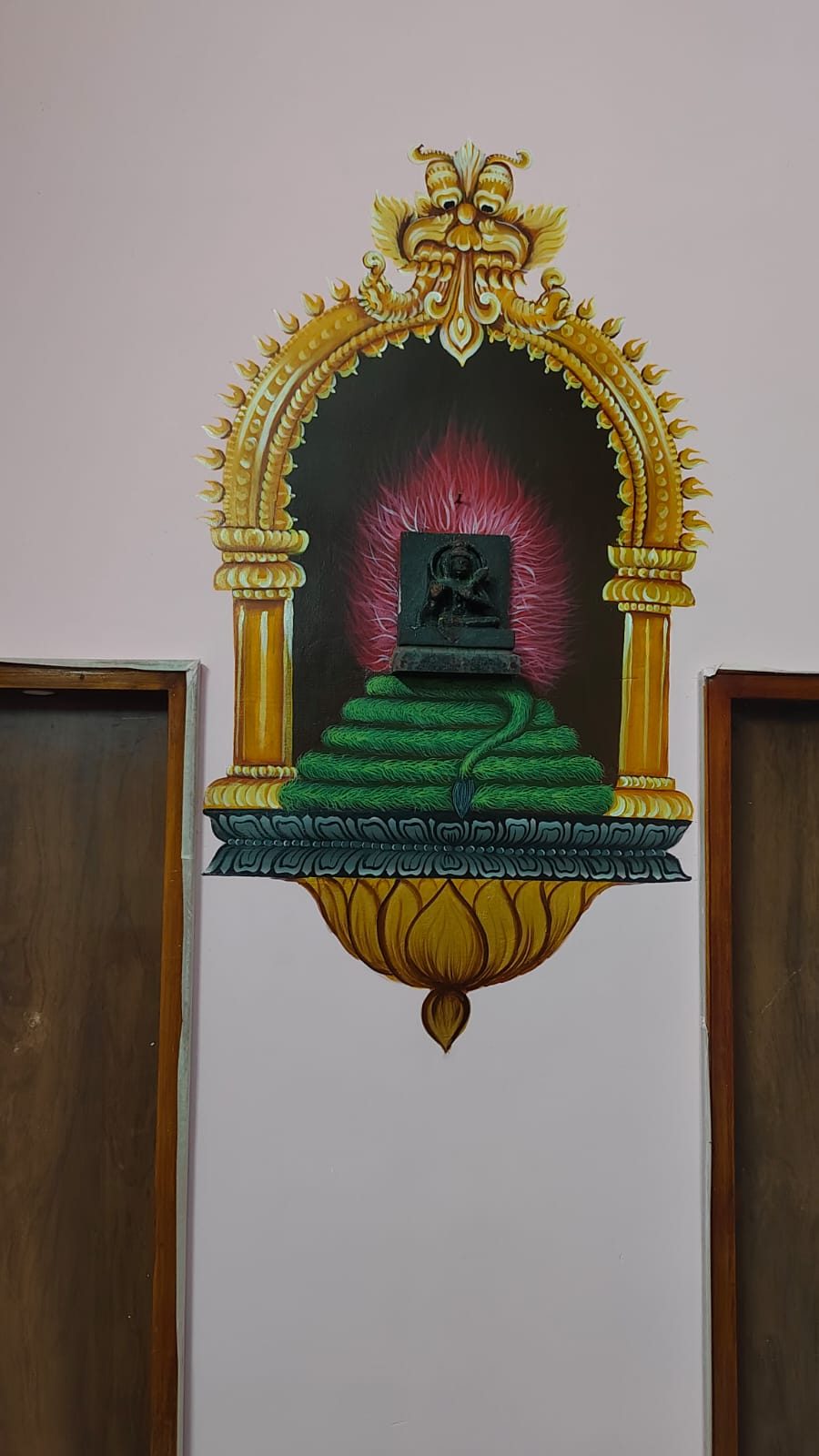 Painted temple niche with a golden arch and lingam